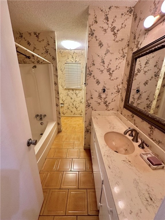 bathroom featuring washtub / shower combination, a textured ceiling, and vanity