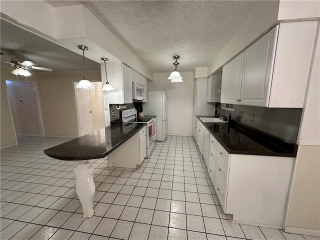 kitchen featuring white cabinetry, light tile patterned floors, sink, a breakfast bar area, and white appliances