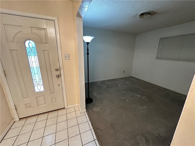 entryway with light colored carpet and a textured ceiling