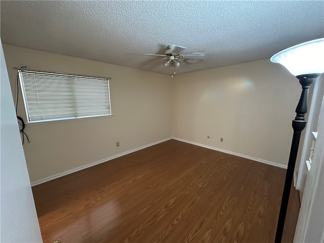 spare room with a textured ceiling, dark wood-type flooring, and ceiling fan