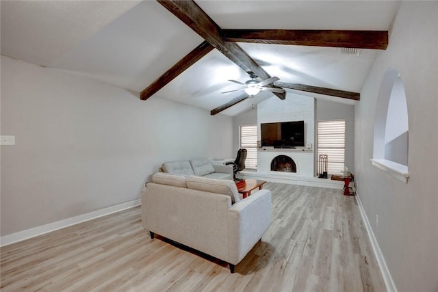 living room featuring ceiling fan, a fireplace, lofted ceiling with beams, and light hardwood / wood-style floors