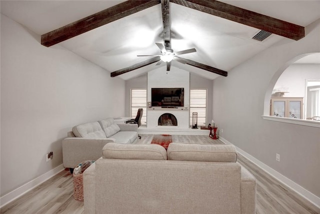 living room with a large fireplace, light hardwood / wood-style floors, ceiling fan, and lofted ceiling