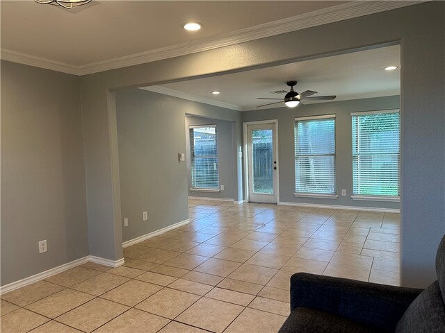 empty room featuring ceiling fan, light tile patterned floors, and crown molding