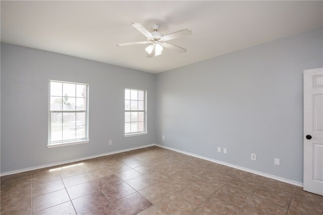 tiled empty room featuring ceiling fan