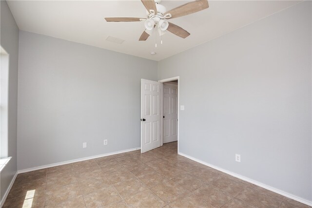 empty room featuring ceiling fan and light tile patterned floors