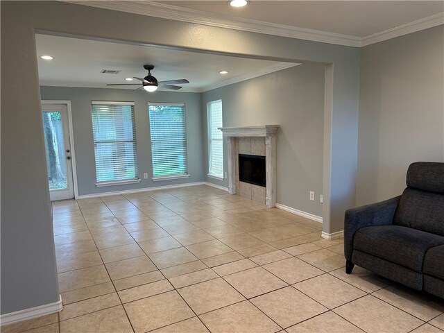 living room featuring ornamental molding, a fireplace, light tile patterned floors, and ceiling fan