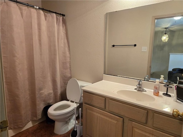 bathroom featuring toilet, tile patterned floors, vanity, and curtained shower