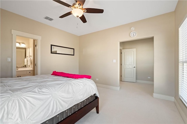 107 Frontenac Ln, Rockport, TX 78382 - bedroom featuring visible vents, baseboards, ceiling fan, ensuite bath, and light carpet