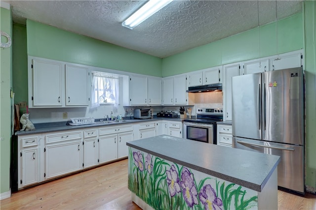 kitchen with stainless steel appliances, white cabinetry, sink, and light hardwood / wood-style flooring