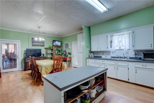 kitchen with white cabinetry, light hardwood / wood-style flooring, and sink