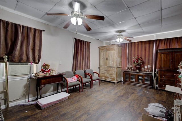 sitting room with a drop ceiling, dark hardwood / wood-style flooring, and ceiling fan