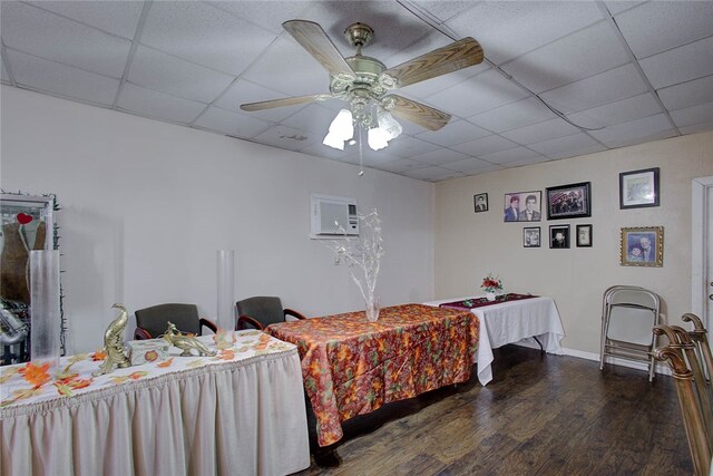 bedroom featuring dark wood-type flooring, a drop ceiling, and ceiling fan