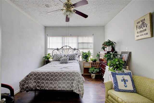 bedroom with ceiling fan, dark hardwood / wood-style floors, a textured ceiling, and ornamental molding