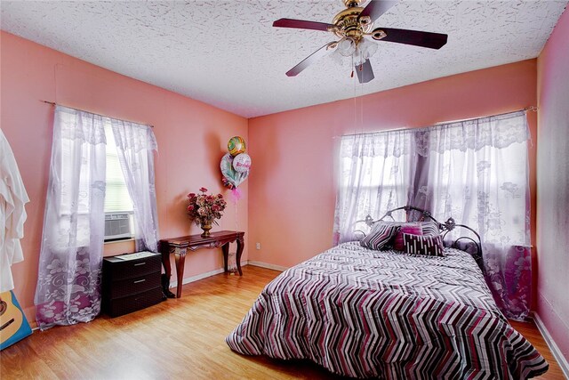 bedroom featuring ceiling fan, a textured ceiling, and light wood-type flooring