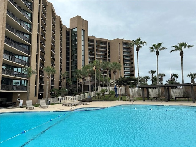 community pool featuring fence and a patio