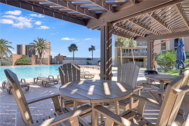 view of patio / terrace with a pergola, a community pool, outdoor dining space, and fence