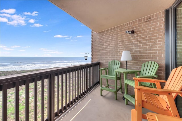 balcony with a water view and a beach view
