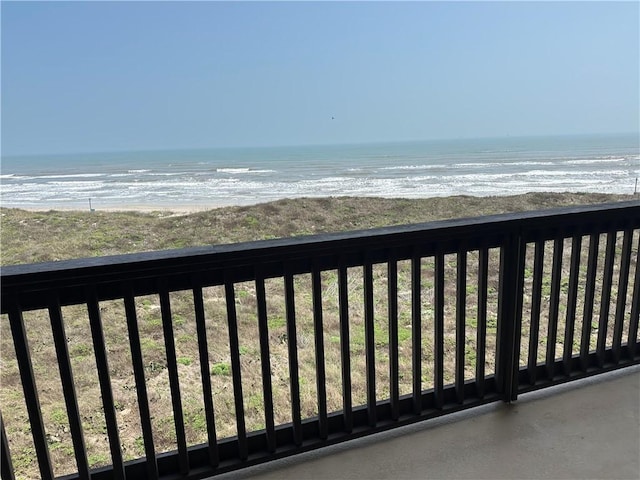 balcony with a water view and a view of the beach