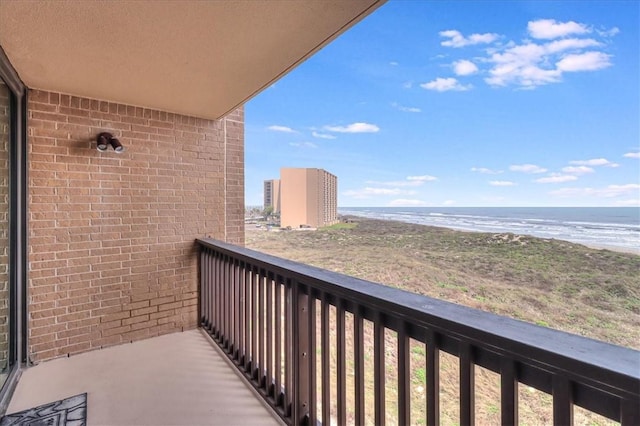 balcony featuring a water view and a beach view