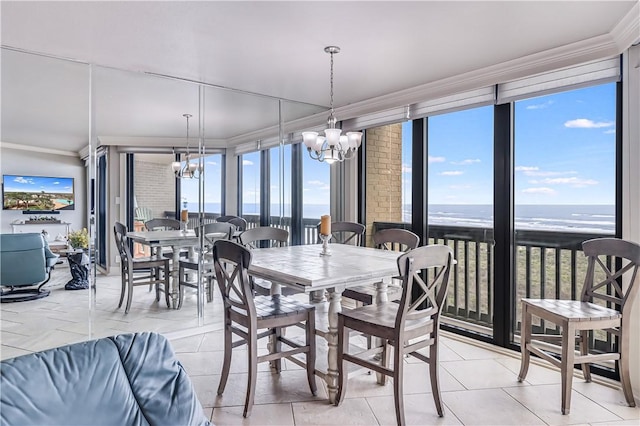 dining space with light tile patterned flooring, expansive windows, crown molding, a chandelier, and a water view
