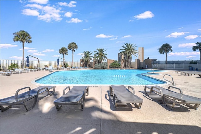 community pool with fence and a patio area