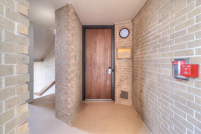 view of exterior entry featuring brick siding
