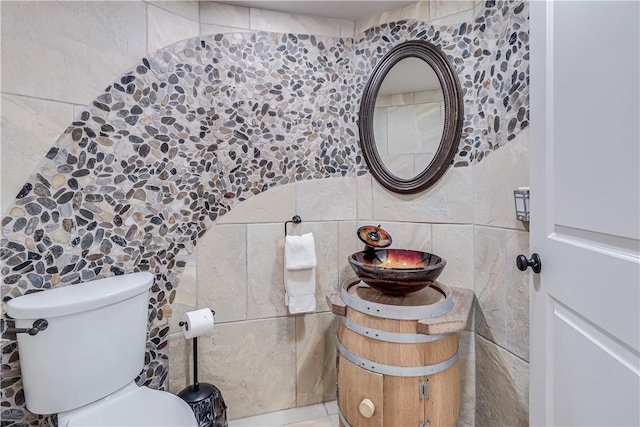 half bathroom with toilet, tile walls, and decorative backsplash