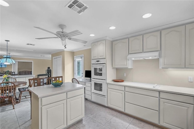 466 Coral, Corpus Christi, TX 78411 - kitchen with white double oven, ornamental molding, light countertops, under cabinet range hood, and recessed lighting