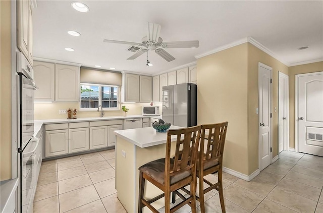 466 Coral, Corpus Christi, TX 78411 - kitchen featuring white appliances, light countertops, a breakfast bar area, ceiling fan, and ornamental molding
