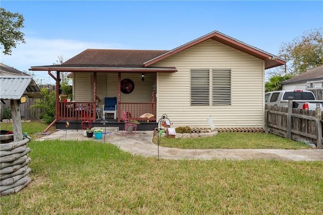 bungalow-style home featuring covered porch, a patio area, and a front yard