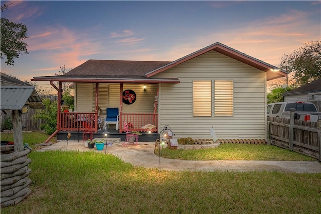 bungalow-style home with covered porch and a yard