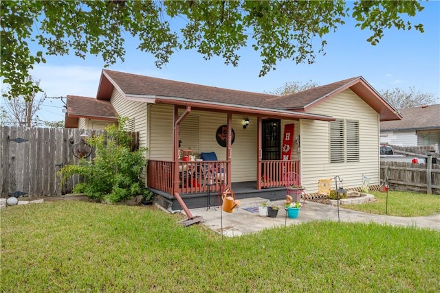 view of front of property featuring a wooden deck, a patio, and a front yard