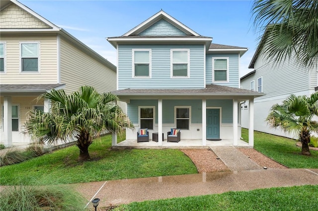 122 Lavaca Cir, Rockport, TX 78382 - coastal home featuring a porch, a front yard, and a shingled roof