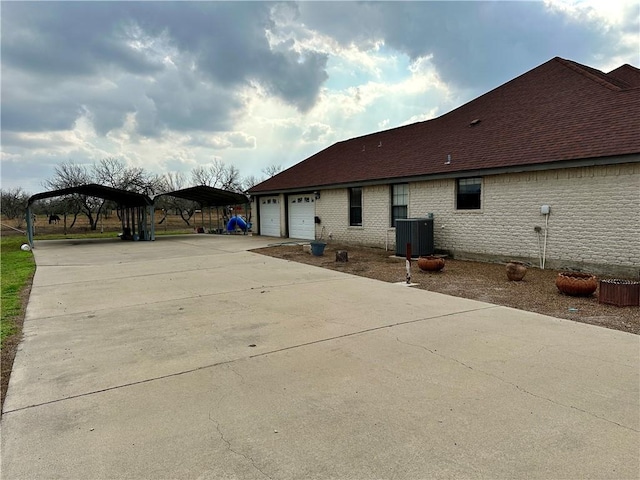 view of side of home with central AC, a carport, and a garage