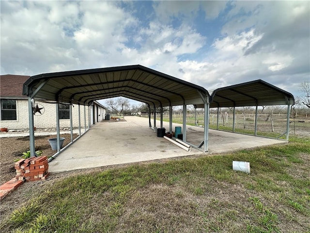 view of parking / parking lot with a carport and a yard