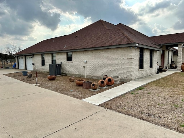 view of home's exterior with a garage and central AC unit