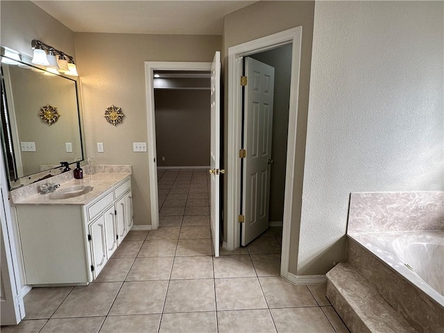 bathroom featuring vanity, tiled bath, and tile patterned flooring