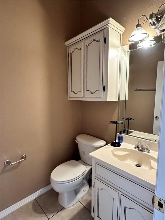 bathroom with tile patterned flooring, vanity, and toilet