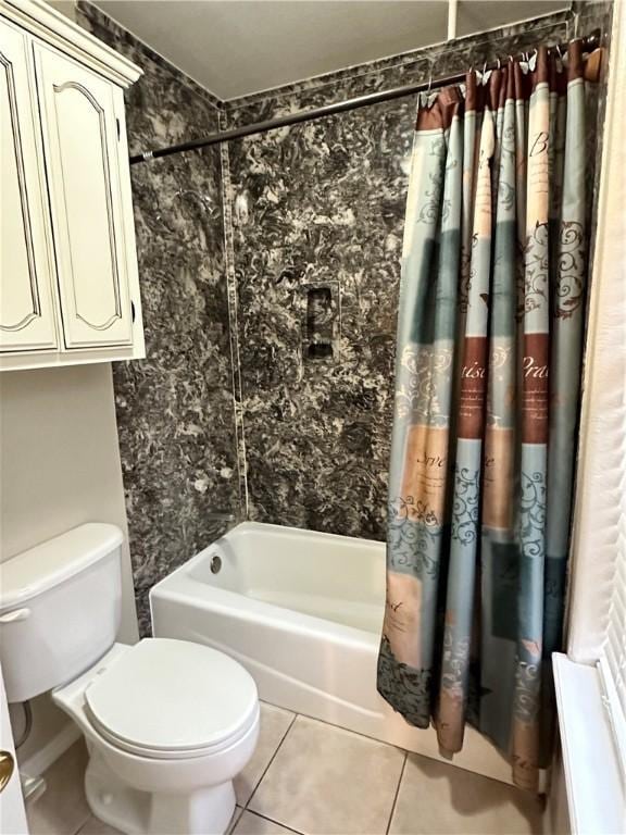 bathroom with tile patterned flooring, shower / tub combo, and toilet