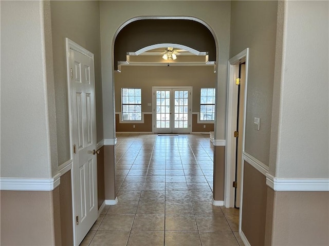 corridor featuring french doors and light tile patterned floors