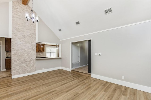 3658 Castle River Dr, Corpus Christi, TX 78410 - unfurnished living room featuring high vaulted ceiling, wood finished floors, and a chandelier