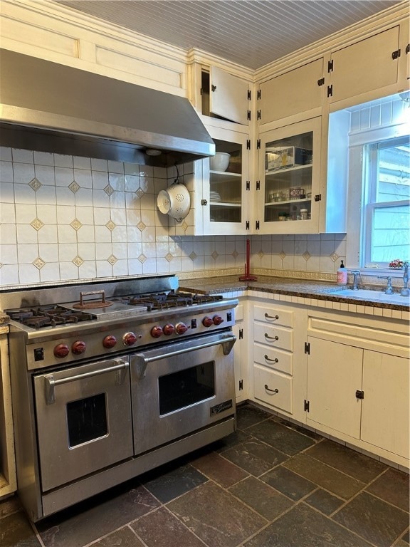 kitchen with double oven range, backsplash, sink, crown molding, and range hood