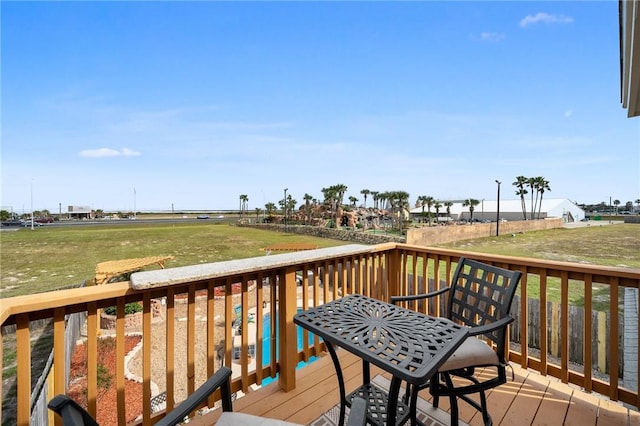 wooden terrace featuring a lawn