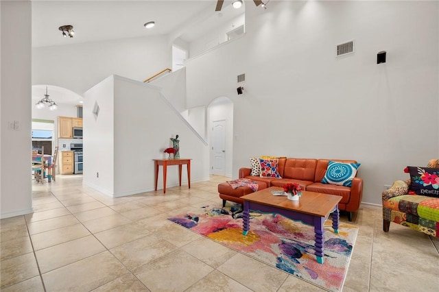 living room featuring high vaulted ceiling and ceiling fan with notable chandelier