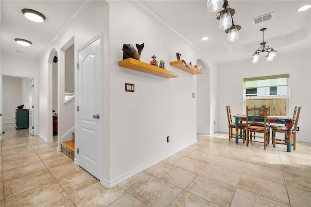 dining space with ornamental molding, a chandelier, and a tray ceiling