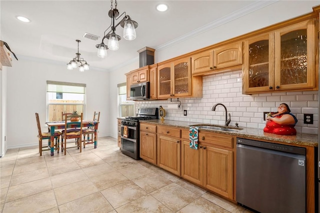 kitchen with sink, crown molding, hanging light fixtures, light stone countertops, and appliances with stainless steel finishes