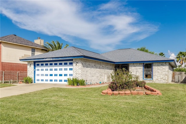 view of front of home with central AC, a front yard, and a garage