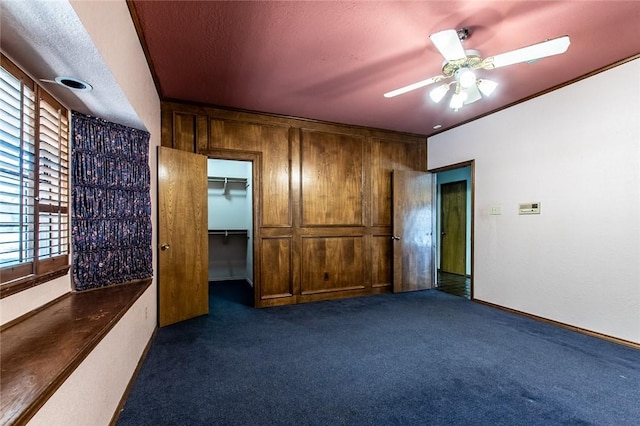 14733 Red River Dr, Corpus Christi, TX 78410 - unfurnished bedroom featuring baseboards, a spacious closet, a ceiling fan, carpet, and wood walls