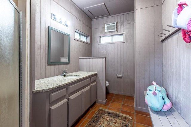 14733 Red River Dr, Corpus Christi, TX 78410 - bathroom featuring toilet, wood walls, vanity, and tile patterned floors