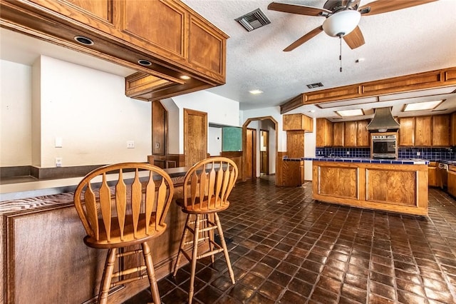 14733 Red River Dr, Corpus Christi, TX 78410 - kitchen featuring brown cabinets, visible vents, ceiling fan, and ventilation hood